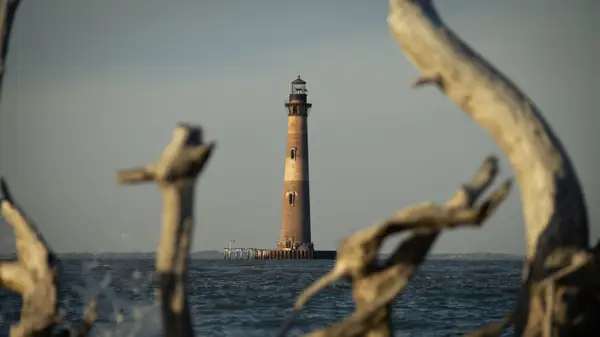 The Morris Island Lighthouse standing in the water off the end of Folly Beach